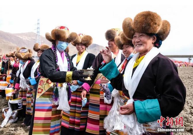 資料圖：西藏自治區(qū)拉薩市曲水縣才納鄉(xiāng)協(xié)榮村參加春耕儀式的村民互敬青稞酒。按照傳統(tǒng)，當(dāng)?shù)卮迕裆碇?jié)日盛裝，舉行隆重的儀式，祈福一年的豐收。<a target='_blank' ><p  align=