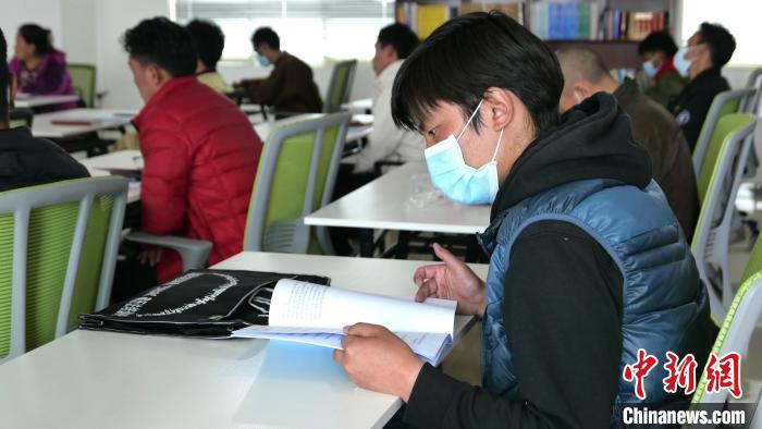 圖為正在閱讀“杰松達(dá)孜”藏歷法教材的學(xué)員?！≈x牧 攝