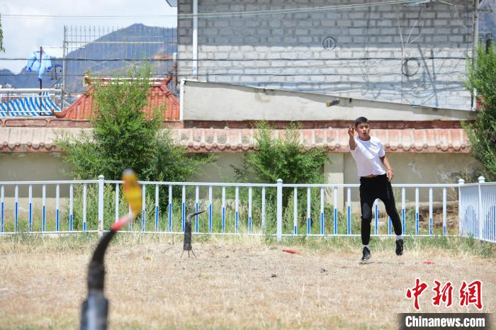 圖為西藏自治區(qū)拉薩市賽馬場(chǎng)內(nèi)市民在體驗(yàn)“打牛角”項(xiàng)目?！∝暩聛硭?攝