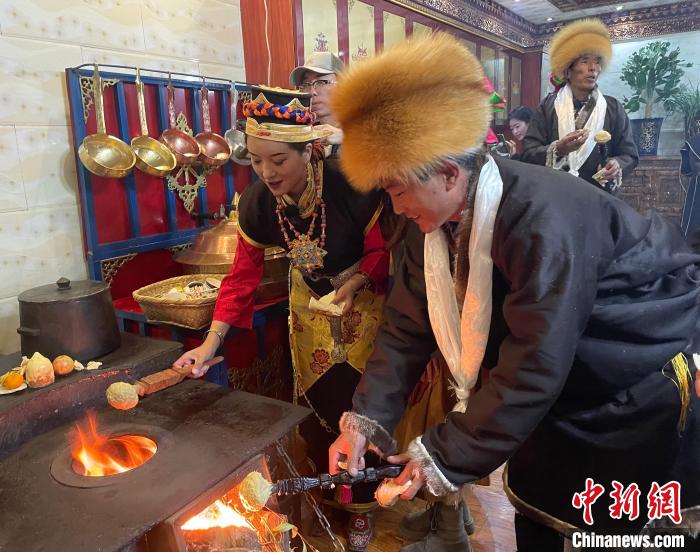 圖為人們?cè)诨鹕峡竟?jié)日美食“結(jié)達(dá)”?！∪轿木?攝