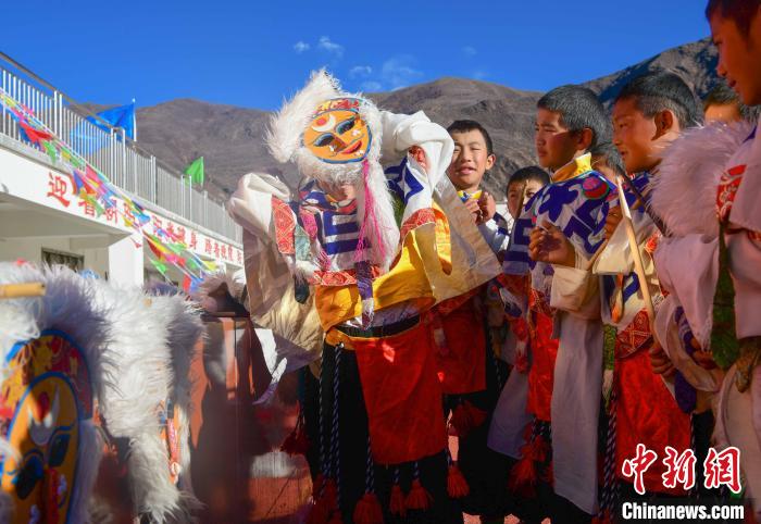 圖為加查縣安繞鎮(zhèn)小學(xué)學(xué)生在試穿藏戲面具?！∝暩聛硭?攝