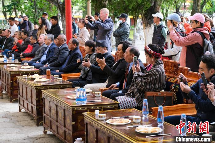 5月19日，中外嘉賓在羅布林卡和游客一起觀看藏戲?！〗w波 攝