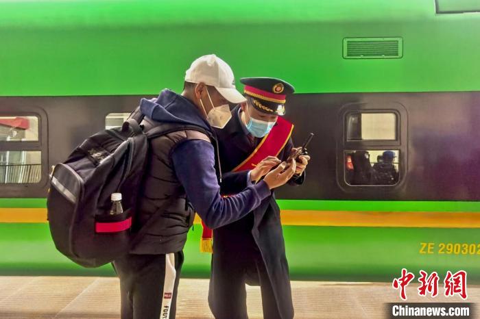 圖為日喀則火車(chē)站工作人員服務(wù)乘客?！《飞降?攝