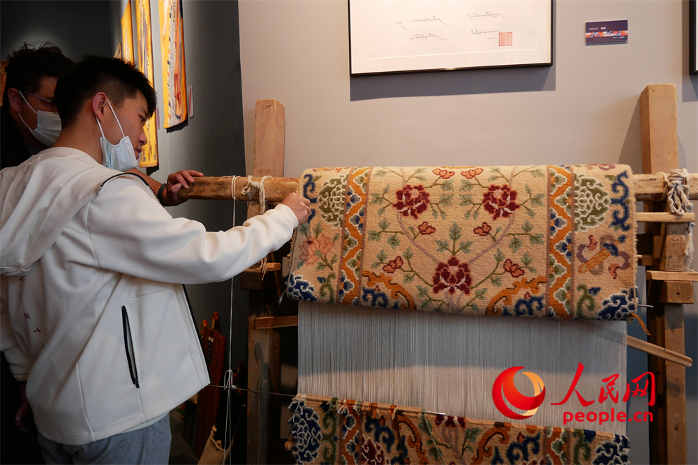 觀眾正在觀賞展出的藏毯。人民網(wǎng) 韋衍行攝