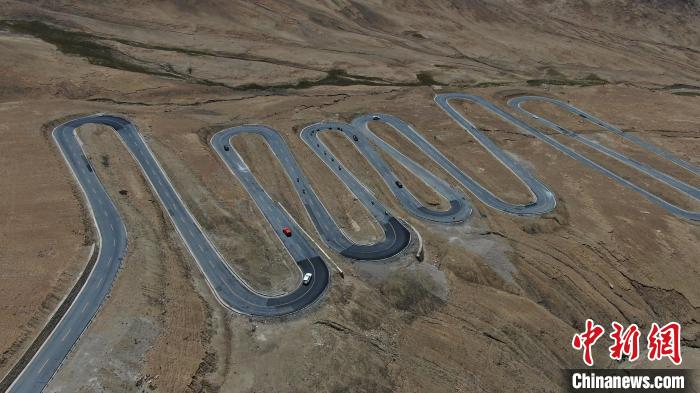 圖為騎手前往珠峰大本營途經(jīng)108道拐?！∮文恋厍蚬﹫D