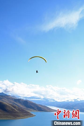 圖為在羊卓雍錯(cuò)，游客體驗(yàn)高空滑翔?！≮w朗 攝