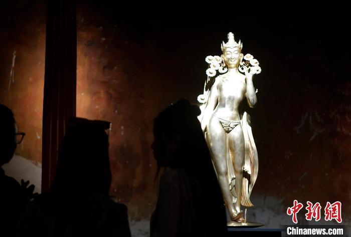 圖為觀眾正在欣賞展覽中的雕塑作品《八萬四千年》?！±盍?攝