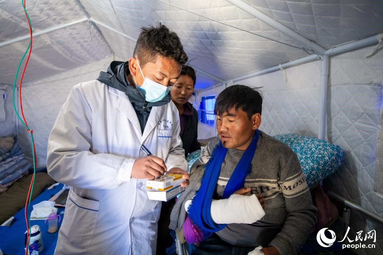 　醫(yī)生正在囑咐洛桑堅參如何用藥。人民網(wǎng)記者 翁奇羽攝