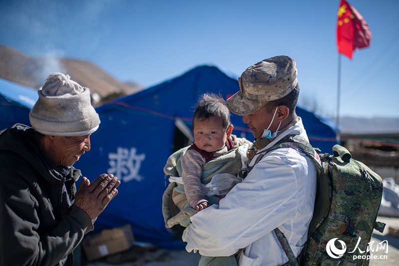 1月9日，在定日縣長所鄉(xiāng)古榮村安置點，受災群眾感謝西藏軍區(qū)陸軍某部隊衛(wèi)生員的醫(yī)療救治。人民網(wǎng)記者 翁奇羽攝