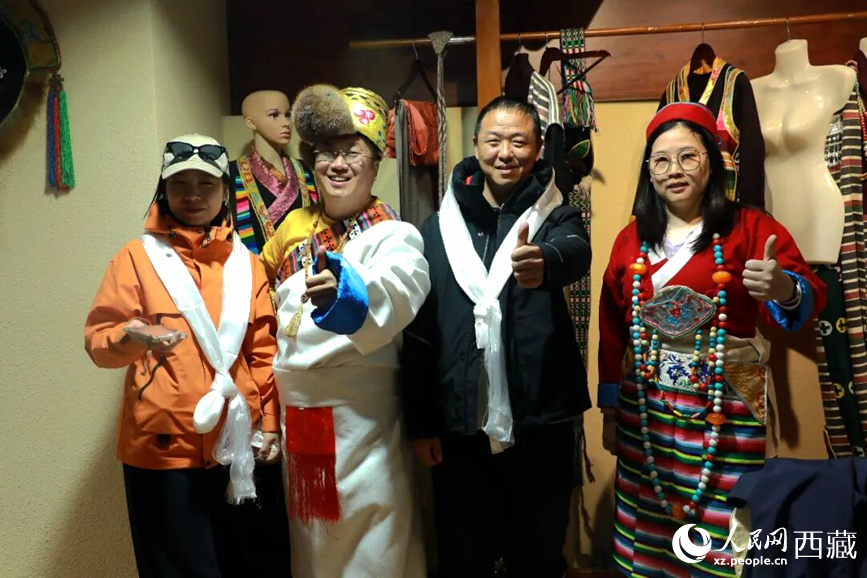游客在扎西曲登社區(qū)體驗藏族服飾文化。大家身著色彩鮮艷的藏裝，佩戴特色飾品，臉上洋溢著喜悅的笑容。人民網(wǎng)記者 吳雨仁攝