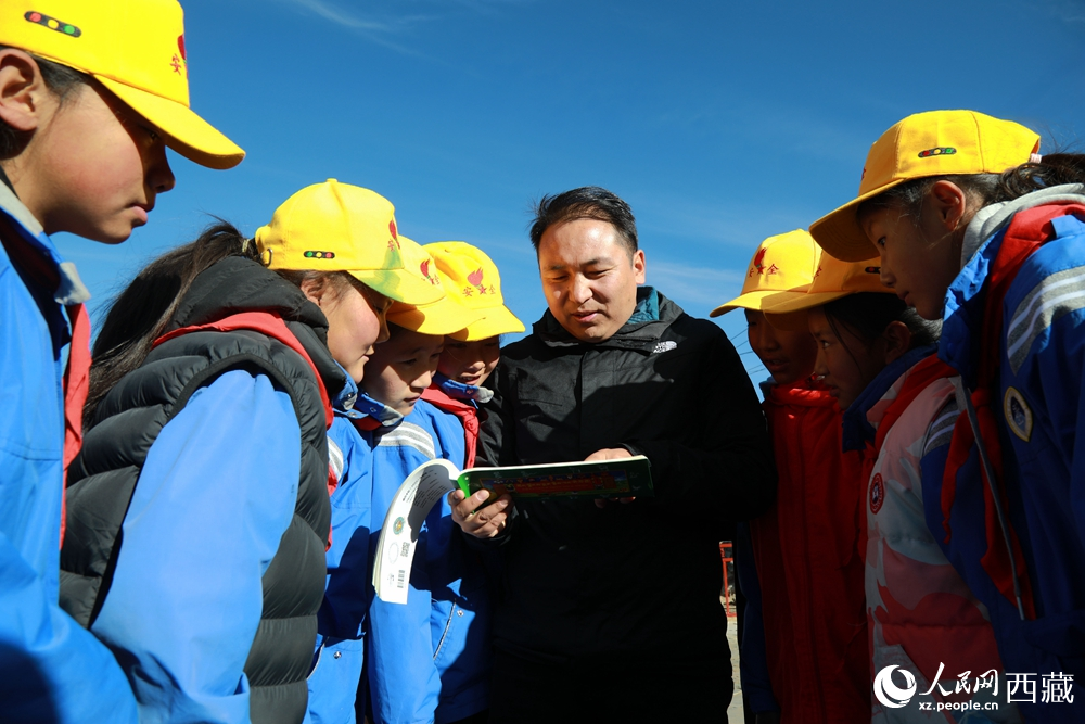 西藏自治區(qū)藏醫(yī)院專家為拉東村小學(xué)生講解天文歷算原理，孩子們圍站聆聽(tīng)，感受傳統(tǒng)智慧與現(xiàn)代科普的融合。人民網(wǎng)記者 吳雨仁攝