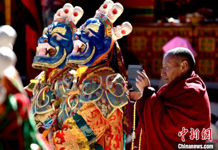 2月19日，正在拍攝跳神活動的僧人。　李林 攝