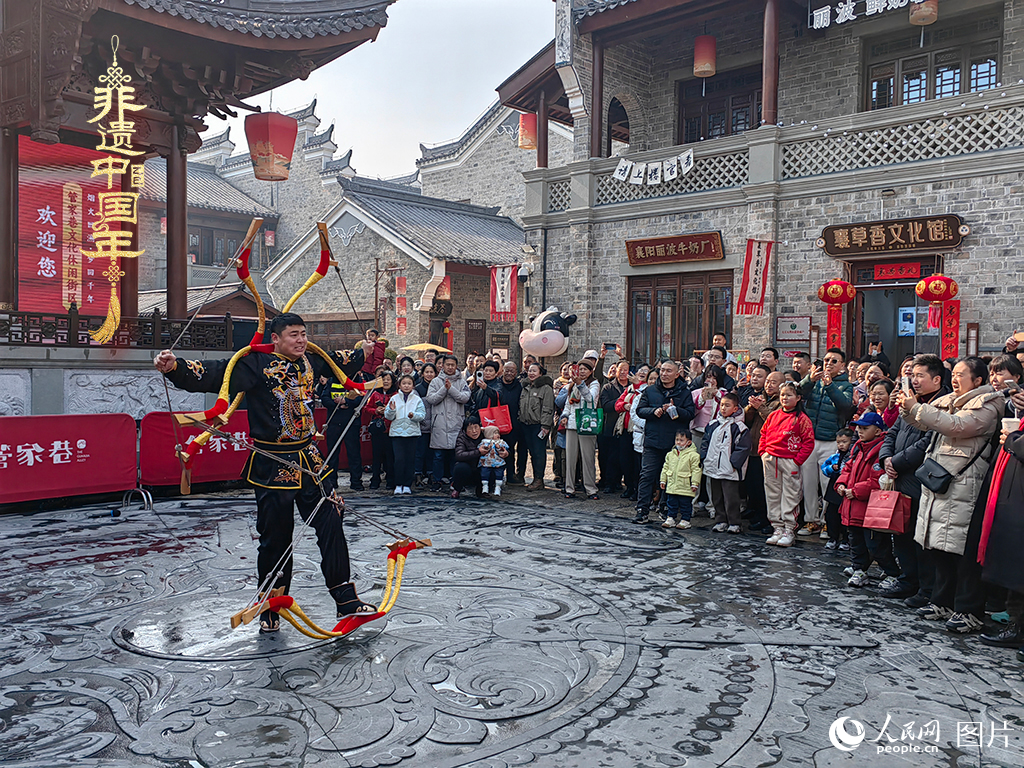 2025年1月29日，湖北襄陽(yáng)市管家巷，老北京天橋大刀張舉大刀拉硬弓第五代傳承人現(xiàn)場(chǎng)表演，一次拉開(kāi)6張弓，引來(lái)游客喝彩。人民網(wǎng)記者 郭婷婷攝