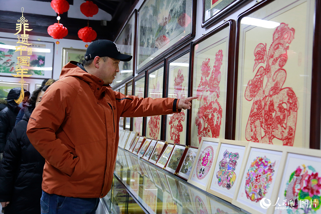 2025年1月23日，游客在天津楊柳青古鎮(zhèn)欣賞傳統(tǒng)剪紙作品，感受指尖上的古老藝術(shù)。人民網(wǎng)記者 崔新耀攝