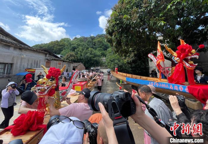 圖為5月29日，長樂江田鎮(zhèn)村民為即將入水的新龍舟安裝龍頭。　張斌 攝