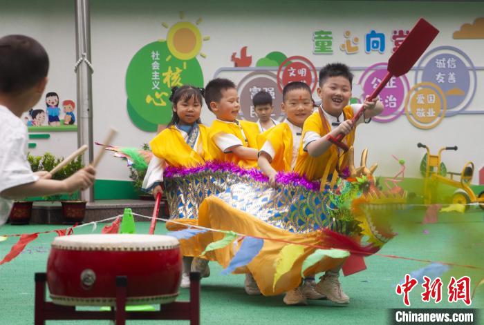 圖為龍舟賽游戲上，小伙伴們打鼓加油。　董觀生 攝