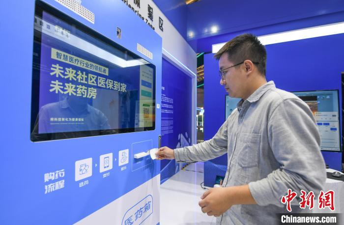 在“中國醫(yī)保 一生守護”展區(qū)，民眾體驗在24小時未來藥房憑“處方”取藥 王剛 攝