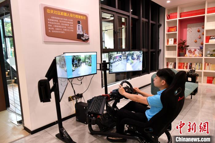 圖為福州中天社區(qū)工作人員正在利用5G技術(shù)，遠(yuǎn)程操控機(jī)器人巡視社區(qū)。　呂明 攝